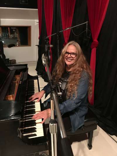 Carrie playing the piano in the studio.